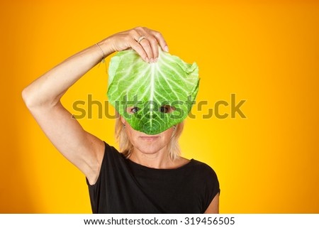 Cute woman holding a cabbage as a mask. Can be used for healthy food concept