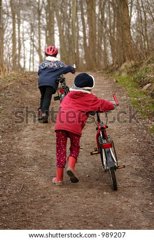 2 children with  bicycle in a forest man and  child in a forest