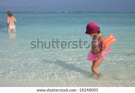 sceneries from the maldivian islands: girl and mother in the turquoise color water