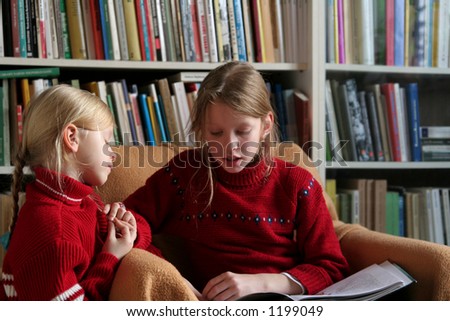 Two sisters reading together