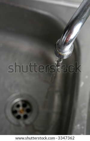 Filling the metallic kitchen sink with water
