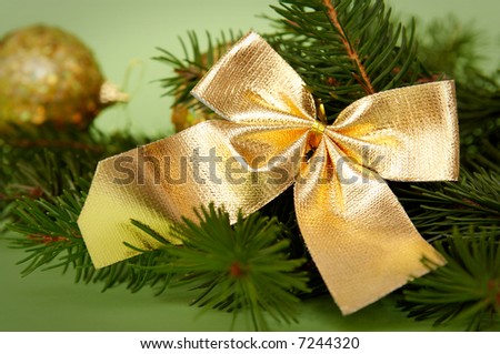 Golden decorations and spruce on a green background