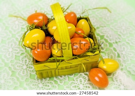 Yellow orange Easter eggs in basket on a light green background