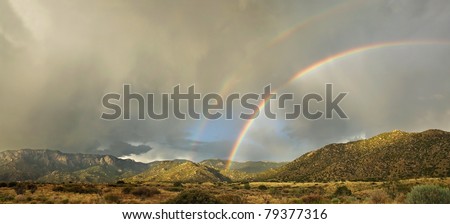A rare double rainbow appears over Albuquerque\'s Sandia Mountains in the monsoon season