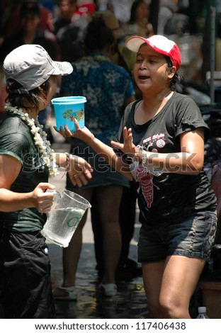 BANGKOK, THAILAND - APRIL 14: Two women in a water fight in the street during the annual Songkran New Year water festival on April 14, 2008 in Bangkok.