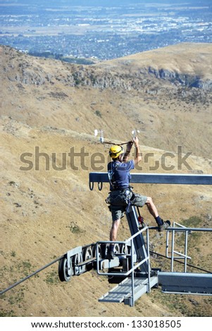 CHRISTCHURCH, NEW ZEALAND - MARCH 25, 2013: Man repairs Gondola weather vane high above the Port Hills on March 25, 2013 in Christchurch.