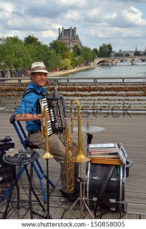 PARIS, FRANCE - JULY 26, 2013: One Man Band Entertains tourists on the Pont Des Arts bridge on July 26, 2013 in Paris.