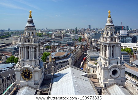 Aerial view of the City of London through the twin Towers of St. Paul\'s Cathedral and the Thames River in the background.