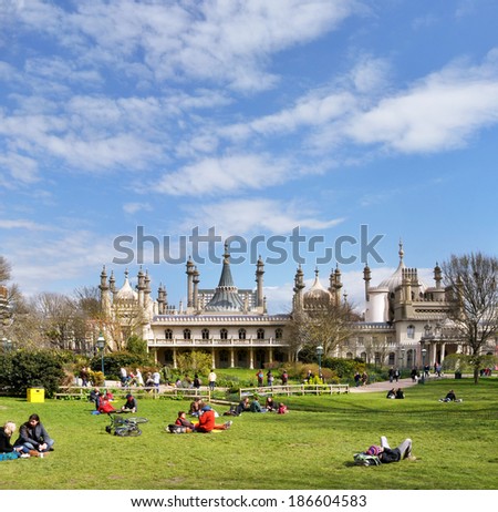 BRIGHTON, UNITED KINGDOM - APRIL 16, 2012: Vertical panorama view of tourists & picnic on the grass outside the historic Royal Pavilion in Brighton. Plenty of copy space available.