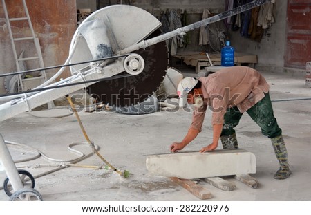 Ha Long Bay, Vietnam - April 17, 2015: Man cutting a block of white Marble in a Ha Long Bay  Ceramics factory.