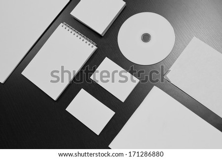 Blank stationery set on black wood background / a4 paper, business cards, letterheads, disk, envelope, booklet, notepad