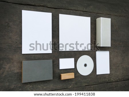 Blank stationery set on wood background: business cards, booklet, sheets, notebook, stamp, CD, and boxes. Retro style