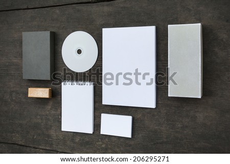 Blank stationery set on old wood background: business cards, booklet, sheets, notebook, stamp, CD, and boxes. Retro style