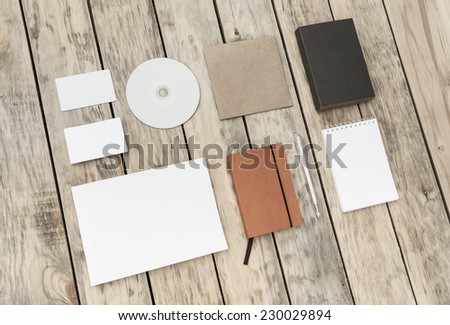 Blank stationery set on old wood background: business cards, plastic card, booklet, notebook, notepad, CD, box and pen. Vintage style