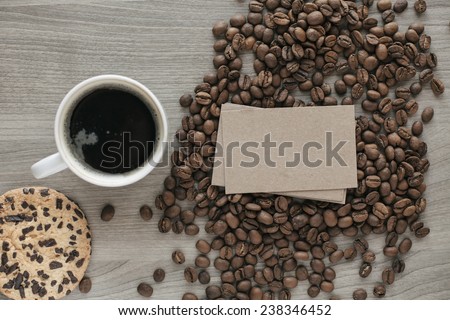Blank a stack of business cards on coffee beans on a wooden texture with a cup of coffee