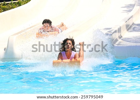 Faliraki,Rhodes,Greek-August,12,2015:Two young girls on the mat racer slide in Water park,Mat racer slide is very popular for young people in the Water Park