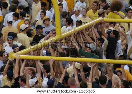College kids tearing down the goalposts at a game