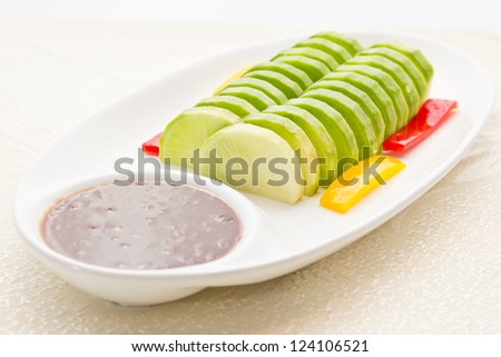 White radish slices on a plate, with a sweet sauce to eat together