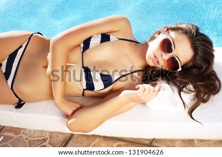 sexy girl in bikini lying near swimming pool. photo from upper point