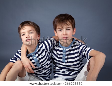 Portrait of happy brothers in studio on  gray background
