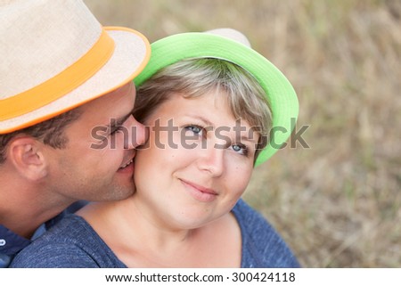Portrait of happy married couple on field background