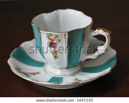 closeup of hand-painted, made in Occupied Japan, antique fine china teacup sitting on antique mahogany teacart