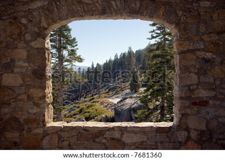 view of Yosemite National Park through the open stone window of a little hut