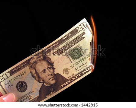 Picture of someone burning a 20 dollar bill.