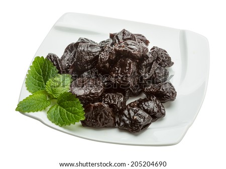 Dried plums with melissa leaves isolated on white