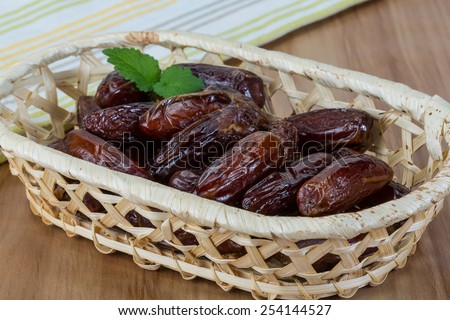 Dry Dates fruit in the bowl on the wood background
