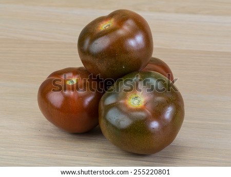 Black tomato - Kumato on the wood background