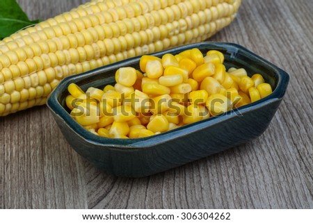Canned sweet corn in the bowl on wood background