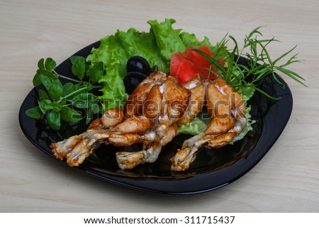 Fried frog legs with olive, herbs and spices
