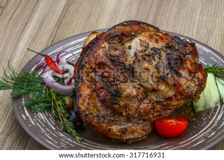 Roasted pork knee with dill and rosemary on the wood background