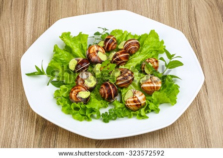 Escargot with parsley butter - served salad and mint leaves