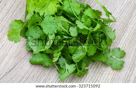 Fresh green Coriander leaves heap on the wood background