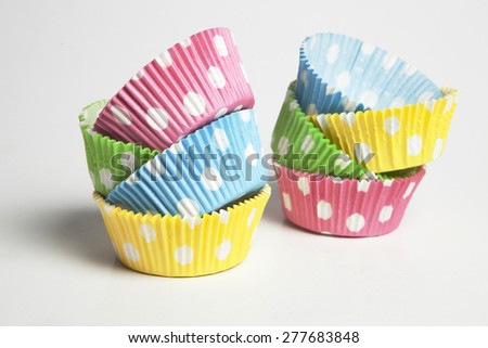 Pink,yellow,blue and green cupcake liners in white background