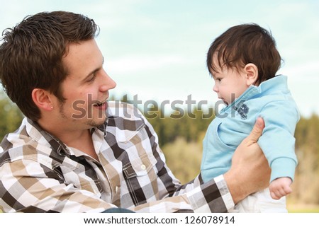 A young happy father 25 years with his 4  month old son.