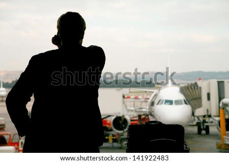 Business man making a last important call before his flight is leaving...