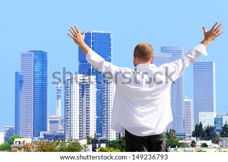 Happy man standing and looking at a cityscape of modern city