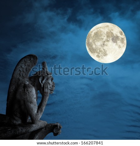 Chimera (demon) from a roof of Notre Dame of Paris looks at the full moon