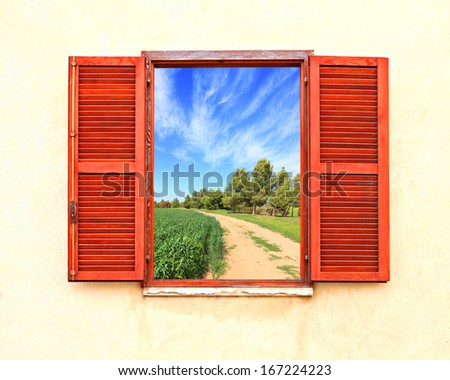 Mediterranean open window with shutters and rural curved road along a green wheat field