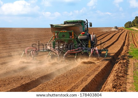 NEGEV, ISRAEL - FEBRUARY 11: John Deere tractor is working in the field on February 11, 2014 in Israel. John Deere is an american company and leading manufacturer of agriculture machinery.