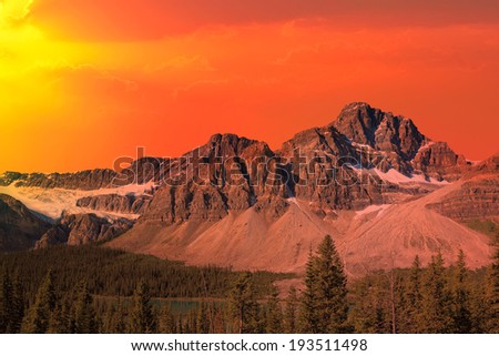 Red sunset over the Rocky mountains and Bow lake coniferous woods. Rocky mountains, Alberta, Canada
