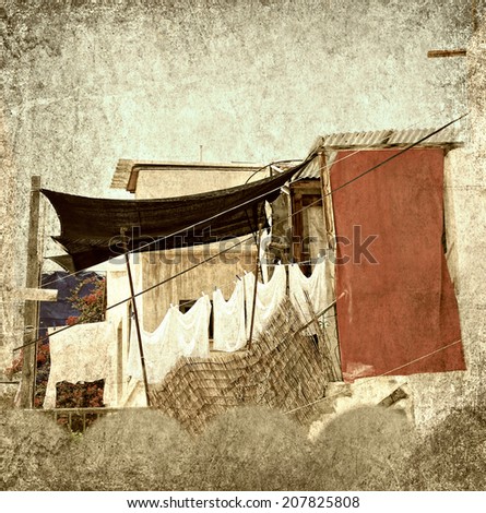 Textured grunge paper background with laundry line and clothes in the old yard of the Mediterranean. Vintage style