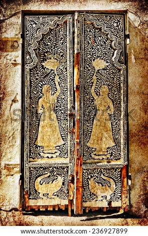 Ancient wooden east pattern decorated door of sandstone traditional building, Middle east. Architectural theme. Photo in retro style. Paper texture. Aged textured photo in retro style