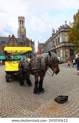 BRUGES,BELGIUM-OCTOBER 04:Horse-drawn carriage on the market square in  historic city center.The Bruges historic city center is a prominent World Heritage Site of UNESCO.Belgium on October 04, 2014