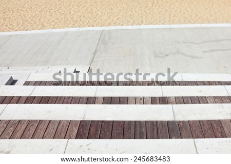 Stairs made of concrete and wood going down to the sandy beach