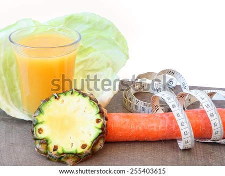 Healthy food and drink for diet as fruit, vegetables and glass of fresh (mix juice) with measurement tape on a white background