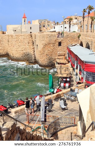 ACRE,ISRAEL- APRIL 04, 2012: Morning view of the fortification wall of Ancient Acre (Akko) and modern cafe.Acre (Akko) is famous tourist site of Israel,Mediterranean. Old town is UNESCO World Heritage